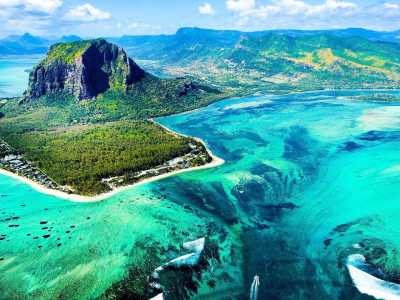 Luftaufnahme von Le Morne Brabant auf Mauritius mit türkisblauem Wasser und optischer Unterwasser-Wasserfall-Illusion.