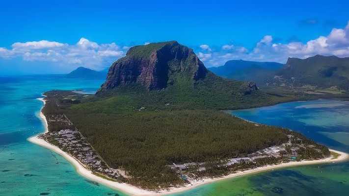 Luftaufnahme der Halbinsel Le Morne auf Mauritius mit ihrem markanten Berg, umgeben von türkisfarbenem Meer und weißen Sandstränden